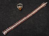 un gros plan d'un bracelet et d'une bague posés sur une surface noire