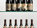 several bottles of wine are lined up on a glass shelf