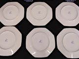 six white plates are arranged on a black surface