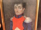 portrait d'un homme en uniforme rouge et bleu tenant une coupe en argent