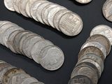several silver coins are arranged in a row on a black surface