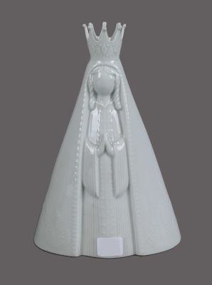 white porcelain figurine of a woman with a crown on her head