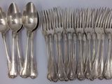 a lot of silver spoons and spoons on the table