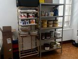 une cuisine équipée d'une cuisinière, d'un micro-ondes et d'étagères