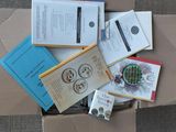 une boîte en carton remplie de livres et de papiers, posée par terre