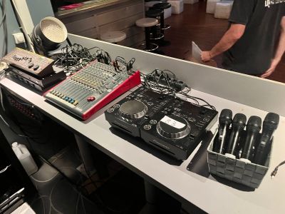un homme debout devant une table sur laquelle sont posés de nombreux appareils électroniques