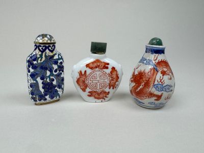 three chinese porcelain snuff bottles, one with a dragon and the other with a dragon on it