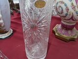 un vase en verre posé sur une table, à côté d'un autre vase posé sur une table
