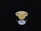 a close up of a gold ring with a coin on it