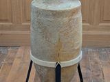 a large vase sitting on a stand on a wooden floor