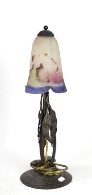 a lamp that is sitting on a stand with a lamp shade on it