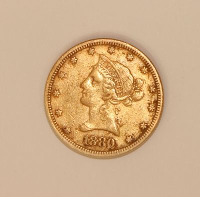 a close up of a gold coin with a woman ' s head on it