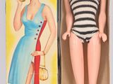 poupée dans une boîte, vêtue d'une robe à rayures bleues et blanches et de chaussures rouges