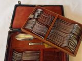 a wooden case with silverware in it on a white surface