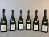 six bouteilles de champagne alignées sur une table