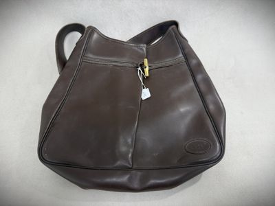 brown leather purse with zippers and a tag on it