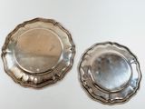 pair of silverplated plates on a white surface
