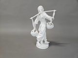 a figurine of a woman holding a basket and a stick