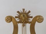 a gold clock with a sunburst on top of it