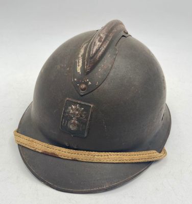 an old helmet with a rope around it on a white surface