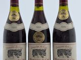 trois bouteilles de vin posées sur une table l'une à côté de l'autre