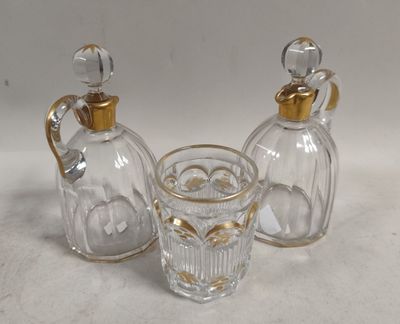 trois bouteilles en verre et un verre à shot posés sur une table