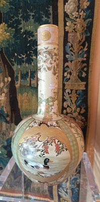 un vase posé sur une table devant une tapisserie