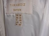 a close up of a white jacket with a tag on it