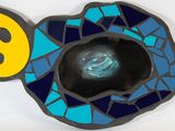 a blue and yellow fish shaped bowl with a hole in it