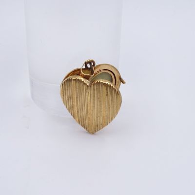 une image représentant une bague en or en forme de cœur, ornée d'un diamant au centre