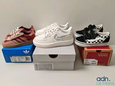 trois paires de chaussures sont posées sur des cartons, sur une table