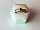 l'image d'une bague en or contenant une pierre rouge