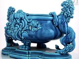un vase bleu orné d'un lion, posé sur une table