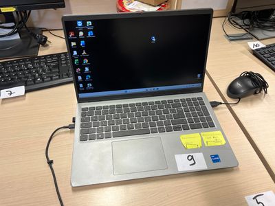 un ordinateur portable posé sur un bureau, à côté d'un clavier