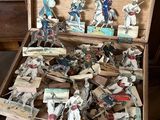 une boîte en bois remplie de figurines représentant des personnes