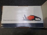 an orange and black chainsaw sitting on top of a cardboard box