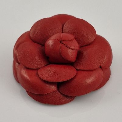 une fleur rouge en cuir sur un fond blanc