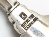 a silver spoon with a silver handle on a white surface