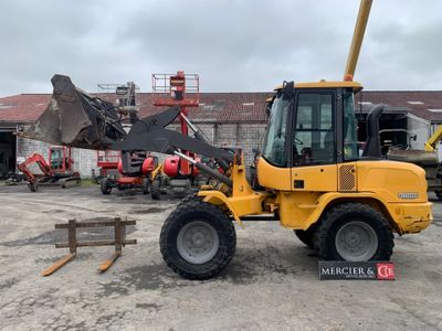 l'arrière d'un engin de chantier jaune garé sur un parking