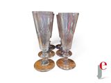 four wine glasses sitting next to each other on a table