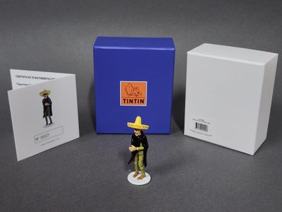 une figurine représentant un homme coiffé d’un sombrero et une boîte de cartes