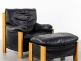 an image of a black leather chair and ottoman in a room