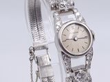an image of a woman ' s wrist watch with a chain around it