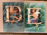 two cards with angels on them on a table