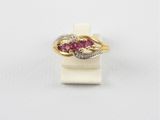 un gros plan d'une bague en or sertie de pierres roses sur un fond blanc