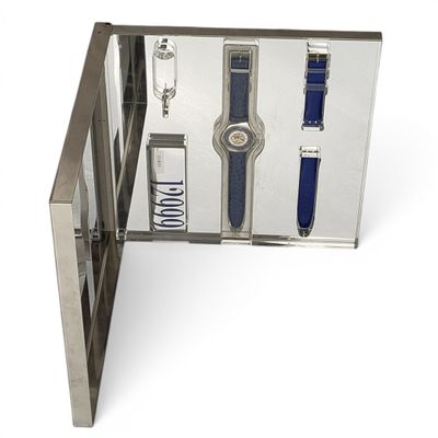 une boîte en métal contenant une montre et un stylo