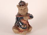 a ceramic bear figurine sitting on a white surface