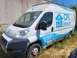 a van that is parked in the grass by a building