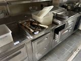 stainless steel counter top in a commercial kitchen with pots and pans on it