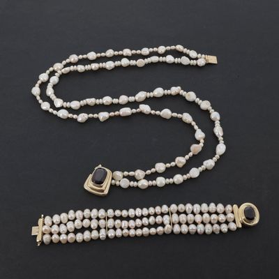 un collier et un bracelet de perles blanches avec un fermoir en or